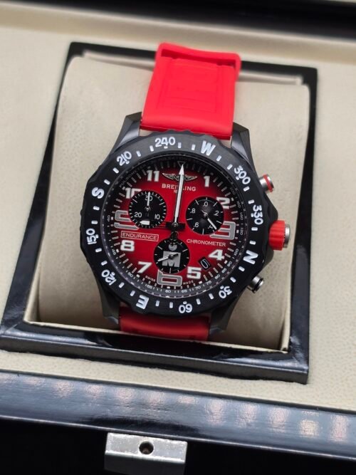Breitling — cronógrafo con esfera roja, caja negra y correa roja
