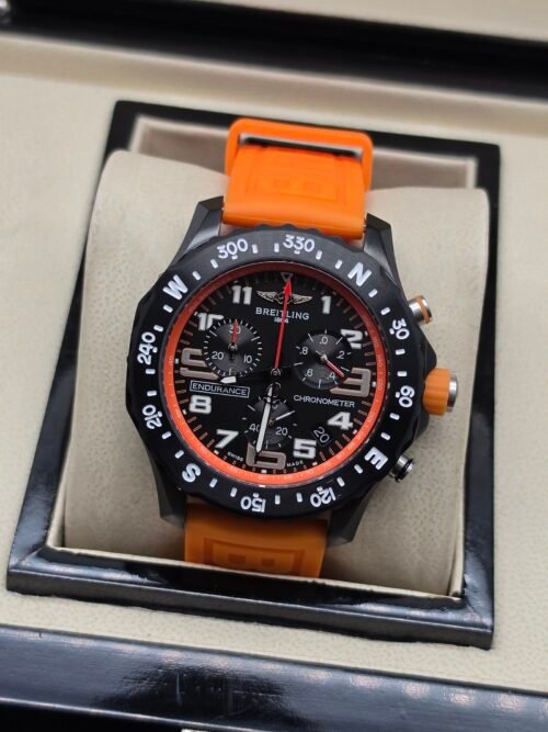 Breitling — cronógrafo negro con aro naranja y correa naranja