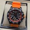 Breitling — cronógrafo negro con detalles naranjas y correa naranja