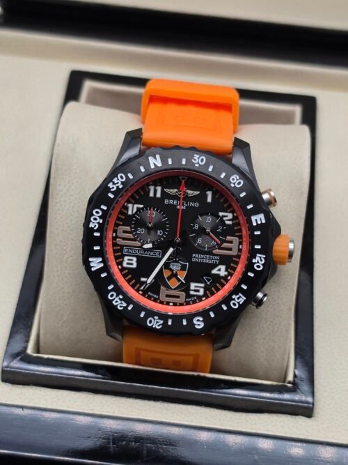 Breitling — cronógrafo negro con detalles naranjas y correa naranja
