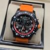 Breitling — cronógrafo negro con aro rojo y azul y correa naranja
