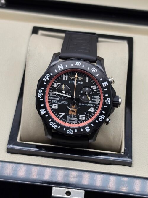 Breitling — cronógrafo negro con aro rosado y correa negra