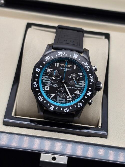 Breitling — cronógrafo negro con aro turquesa y correa negra