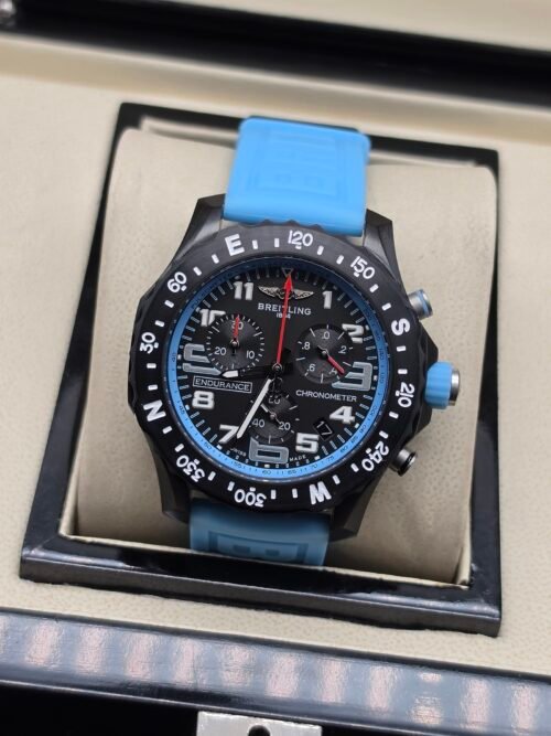 Breitling — cronógrafo negro con detalles celestes y correa celeste