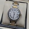 Cartier — caja redonda, esfera blanca con números romanos y brazalete bicolor dorado