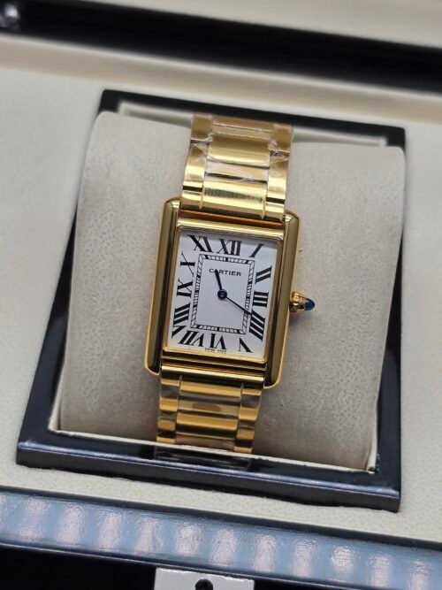 Cartier — caja rectangular dorada, esfera blanca con números romanos y brazalete dorado