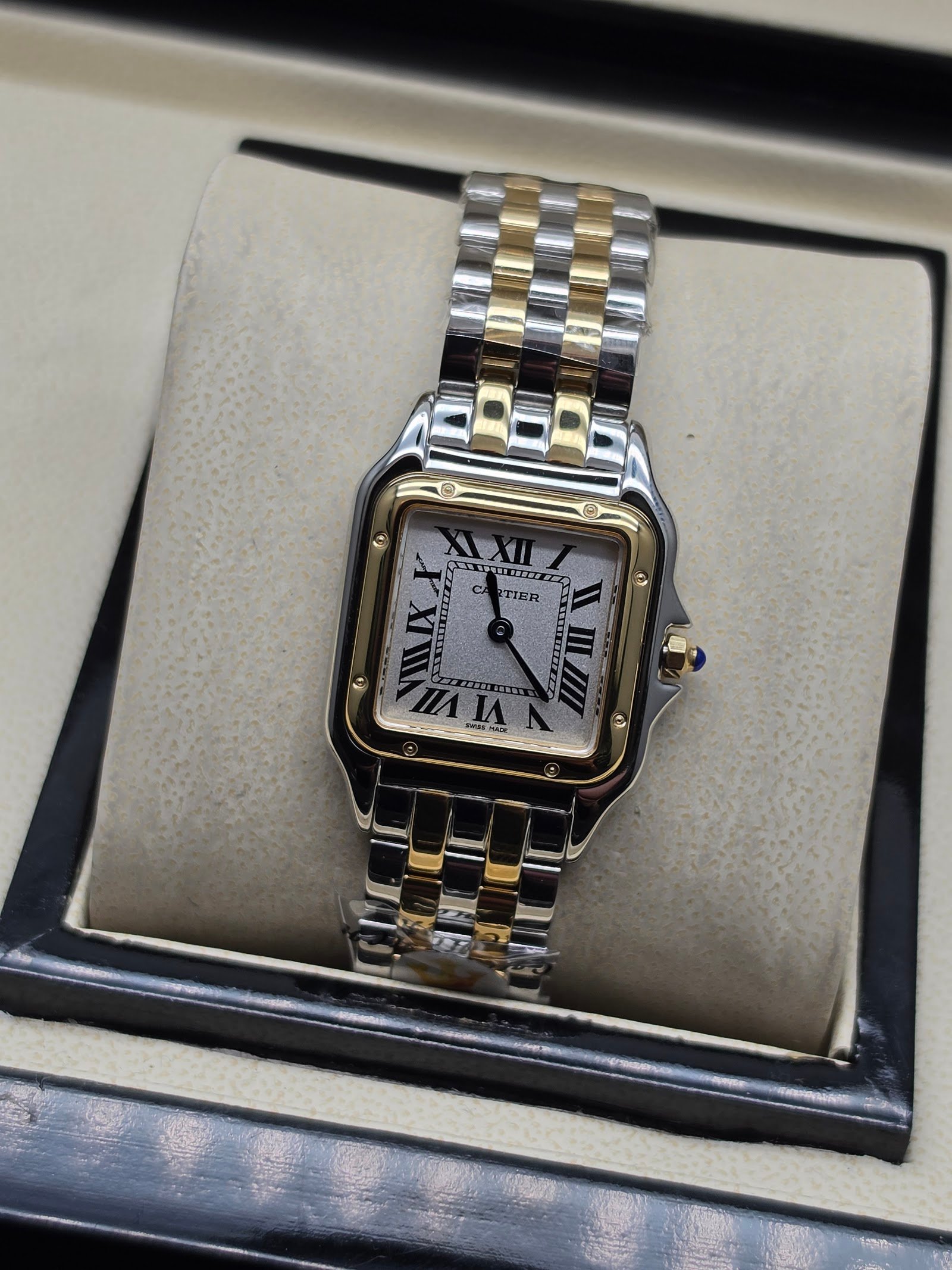 Cartier — caja cuadrada dorada, esfera blanca y brazalete bicolor