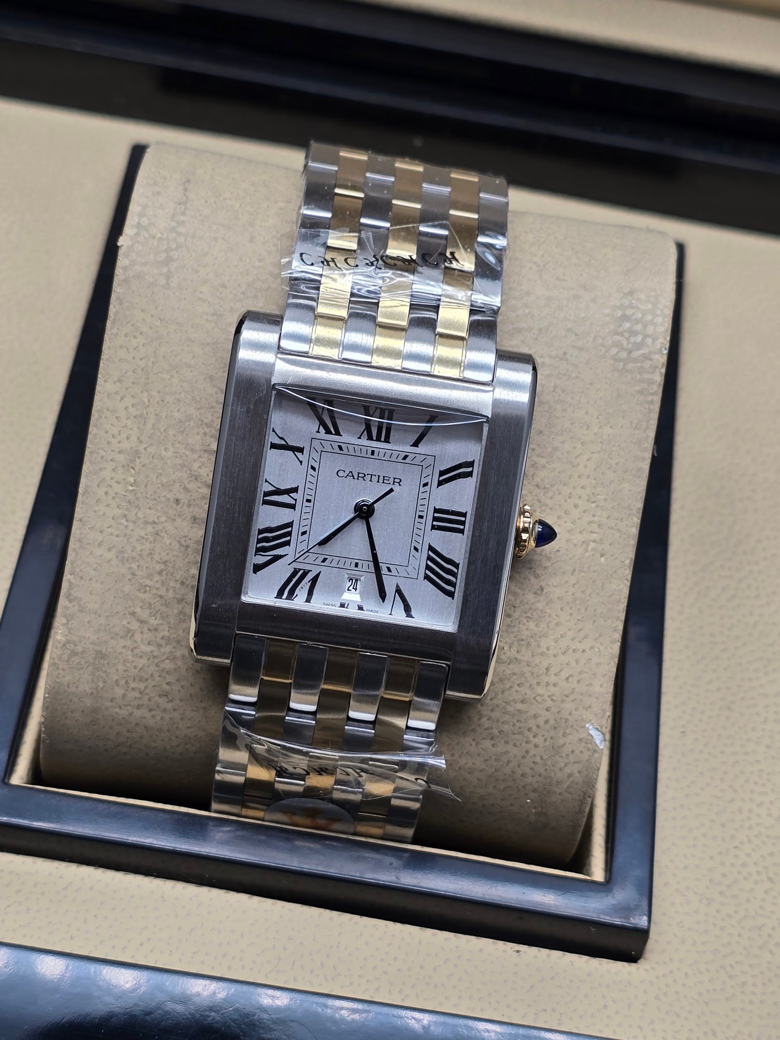 Cartier — caja rectangular de acero, esfera blanca con números romanos y brazalete bicolor