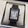 Cartier — caja rectangular negra, esfera blanca con números romanos y correa de cuero negra