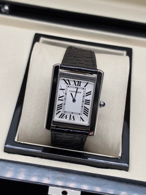 Cartier — caja rectangular negra, esfera blanca con números romanos y correa de cuero negra