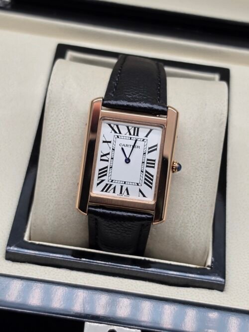 Cartier — caja rectangular oro rosa, esfera blanca con números romanos y correa de cuero negra lisa
