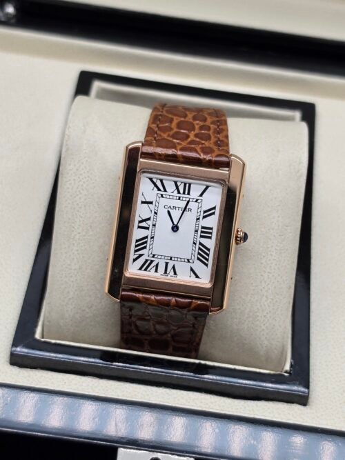 Cartier — caja rectangular oro rosa, esfera blanca con números romanos y correa de cuero marrón