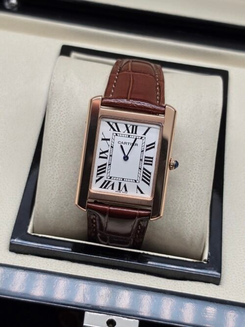 Cartier — caja rectangular oro rosa, esfera blanca con números romanos y correa de cuero marrón oscura