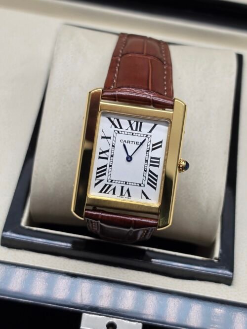 Cartier — caja rectangular dorada, esfera blanca con números romanos y correa de cuero vinotinto