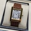 Cartier — caja rectangular dorada, esfera blanca con números romanos y correa de cuero marrón