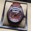 Corum — esfera marrón con números grandes y correa de cuero marrón