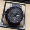 Corum — cronógrafo con esfera gris, caja negra y correa de caucho negra