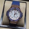 Hublot — cronógrafo con esfera blanca, bisel con piedras azules y caja oro rosa, correa azul
