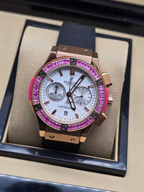 Hublot — cronógrafo con esfera blanca, bisel con piedras fucsia y caja oro rosa, correa negra
