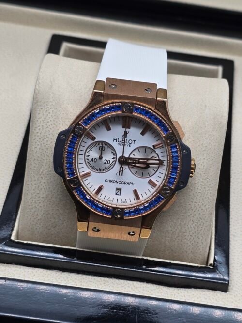 Hublot — cronógrafo con esfera blanca, bisel con piedras azules y caja oro rosa, correa blanca