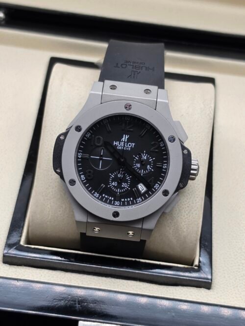 Hublot — cronógrafo con esfera negra, caja gris y correa negra