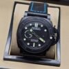 Panerai — esfera negra con detalles verdes, caja negra y correa negra con costuras azules