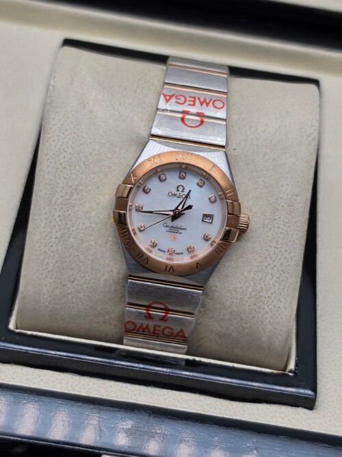 Omega — esfera blanca nacarada, bisel oro rosa y brazalete bicolor