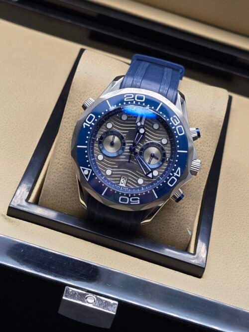 Omega — cronógrafo con esfera gris ondulada, bisel azul y correa de caucho azul