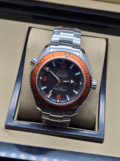 Omega — esfera negra, bisel naranja y brazalete de acero