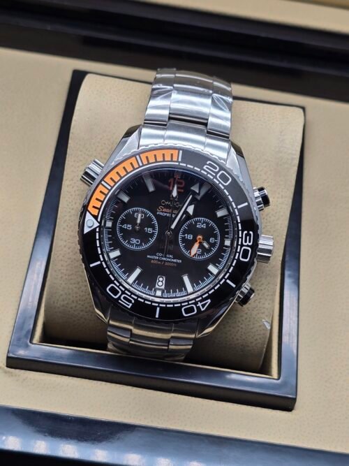 Omega — cronógrafo con esfera negra, bisel negro con detalle naranja y brazalete de acero