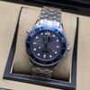Omega — esfera gris ondulada, bisel azul y brazalete de acero