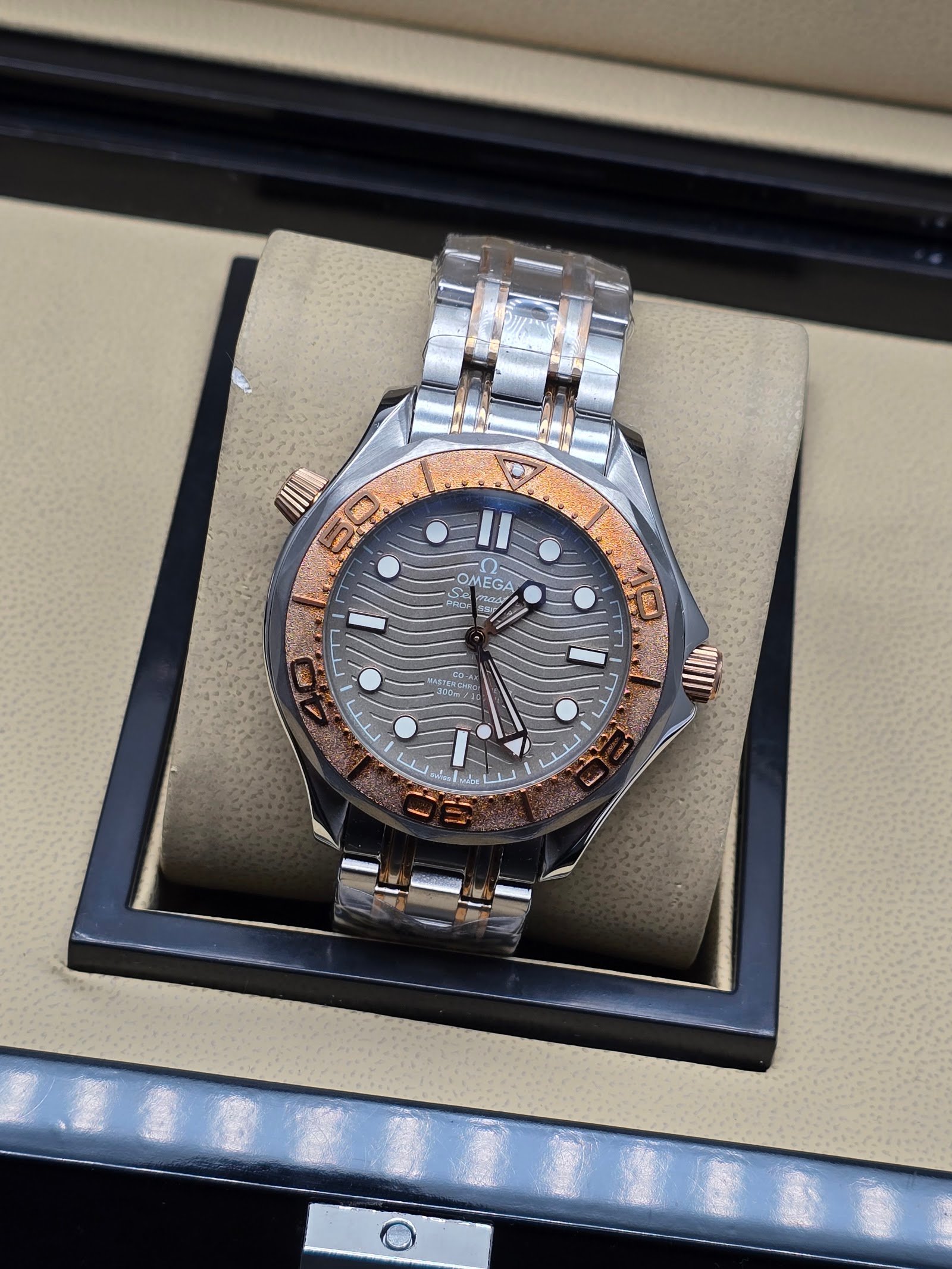 Omega — esfera gris ondulada, bisel oro rosa y brazalete bicolor