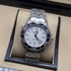 Omega — esfera blanca ondulada, bisel negro y brazalete de acero