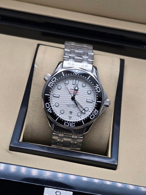 Omega — esfera blanca ondulada, bisel negro y brazalete de acero