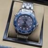 Omega — esfera gris ondulada, bisel azul y brazalete de acero