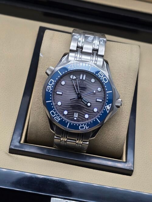 Omega — esfera gris ondulada, bisel azul y brazalete de acero