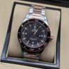 Omega — esfera negra con detalles naranjas, bisel oro rosa y brazalete bicolor