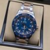 Omega — esfera azul con detalles naranjas, bisel azul y brazalete bicolor