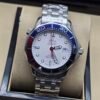 Omega — esfera blanca, bisel azul y rojo y brazalete de acero
