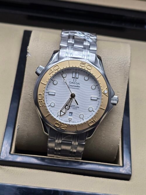 Omega — esfera blanca ondulada, bisel dorado y brazalete de acero