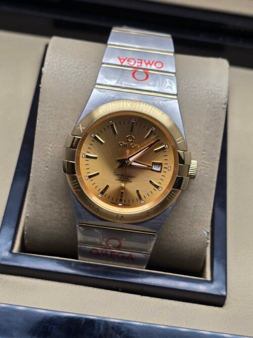 Omega — esfera dorada, bisel dorado y brazalete bicolor