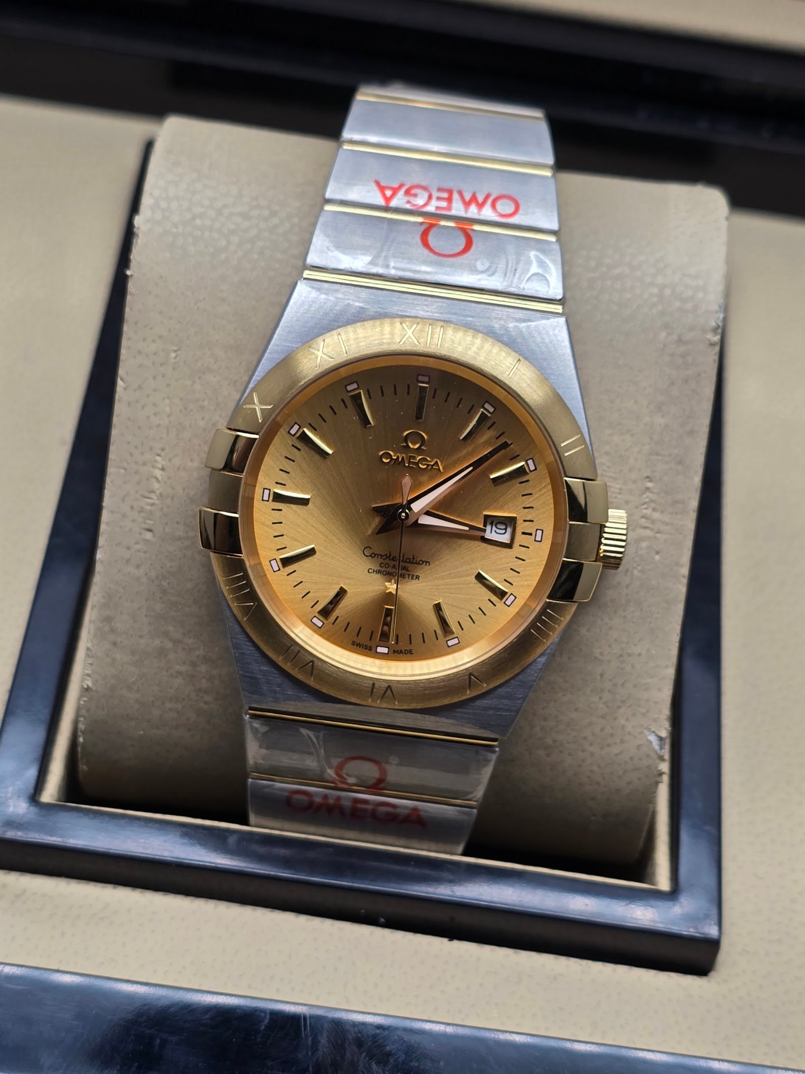 Omega — esfera dorada, bisel dorado y brazalete bicolor