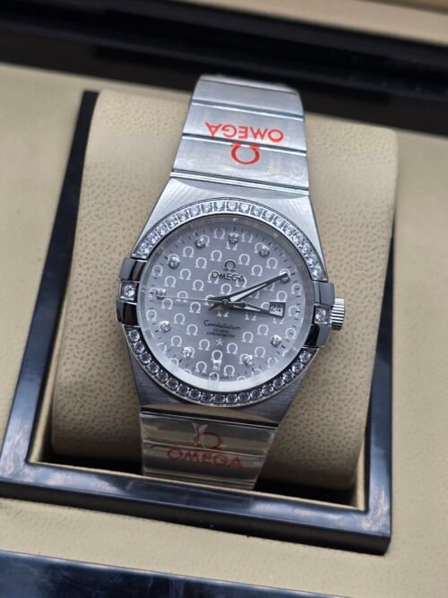 Omega — esfera plateada texturizada, bisel con brillantes y brazalete de acero