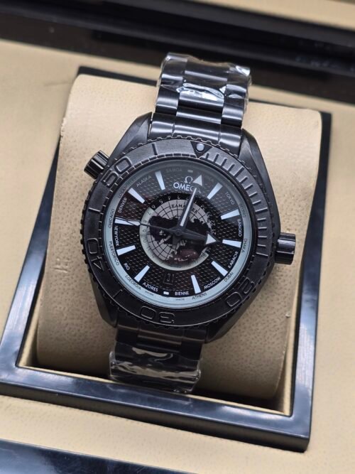 Omega — esfera negra con mapa gris, caja negra y brazalete negro