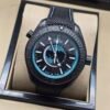 Omega — esfera negra con mapa turquesa, caja negra y correa de tela negra