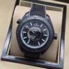 Omega — esfera negra con mapa gris, caja negra y correa de tela negra