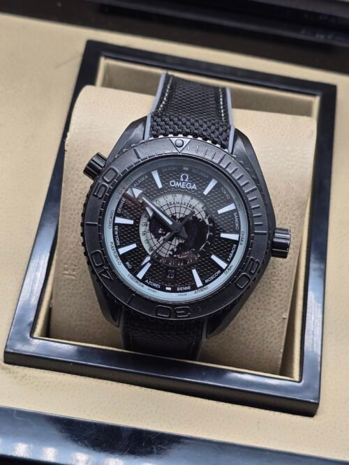 Omega — esfera negra con mapa gris, caja negra y correa de tela negra