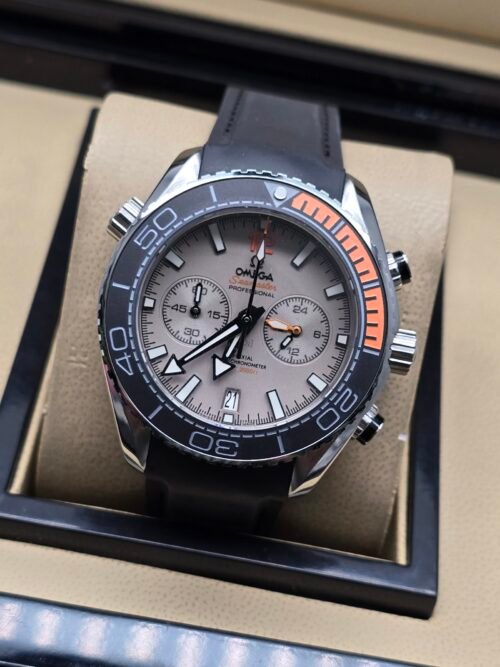 Omega — cronógrafo con esfera gris clara, bisel negro con detalle naranja y correa negra
