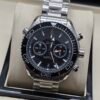 Omega — cronógrafo con esfera negra, bisel negro y brazalete de acero
