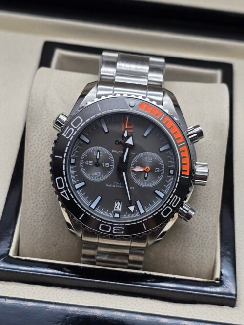 Omega — cronógrafo con esfera gris, bisel gris con detalle naranja y brazalete de acero